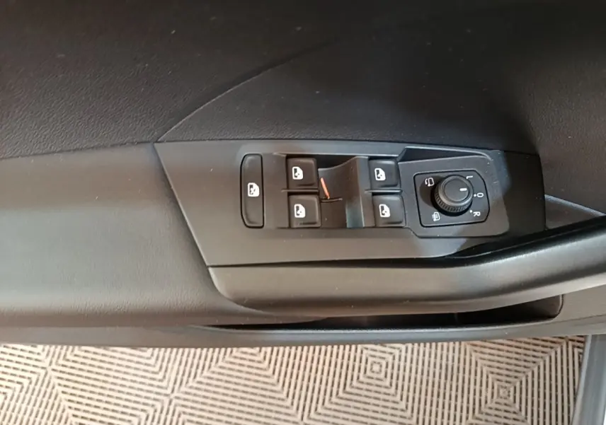 Gros plan sur les commandes des vitres et rétroviseurs côté conducteur d'un Volkswagen T-Cross blanc 2022.