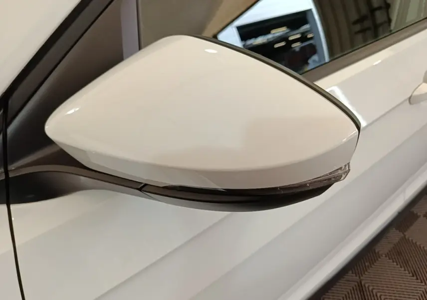Rétroviseur droit blanc de Volkswagen T-Cross 2022, vue rapprochée sur la portière côté droit.