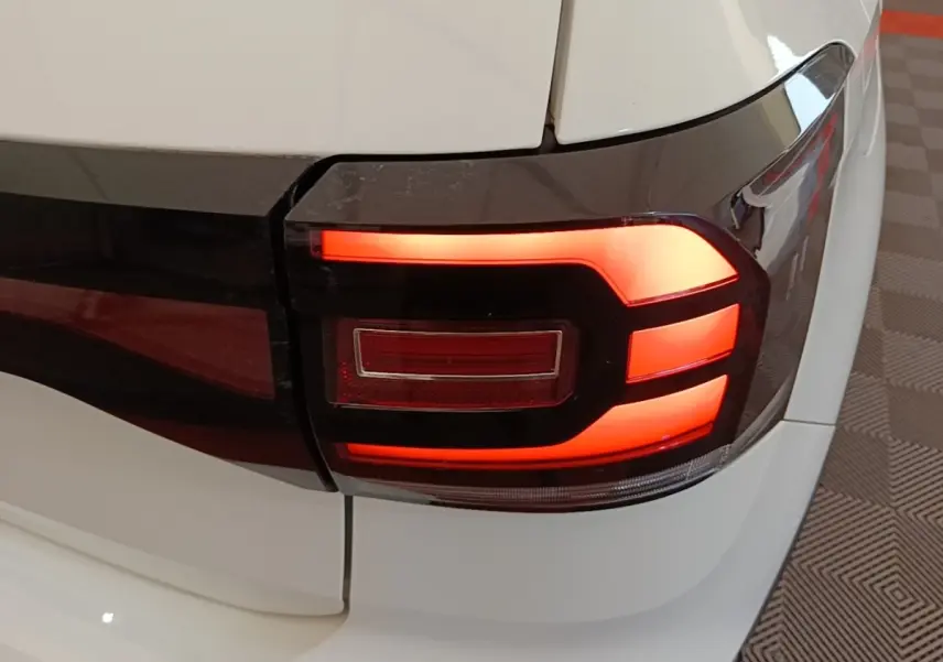 Gros plan sur le feu arrière droit rouge et noir du Volkswagen T-Cross blanc, version 2022 essence.