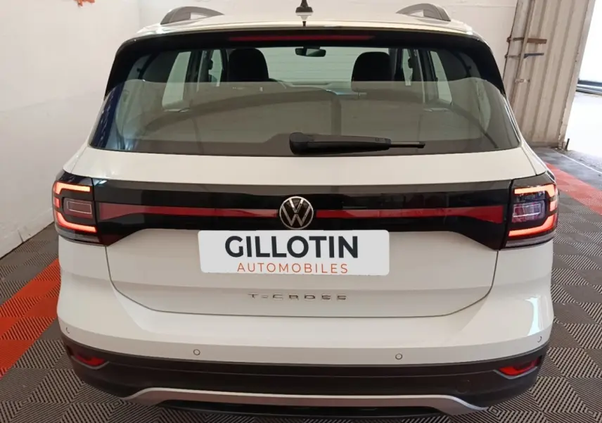 Vue arrière d'un Volkswagen T-Cross blanc 2022 avec feux arrière LED et logo central sur hayon noir brillant.