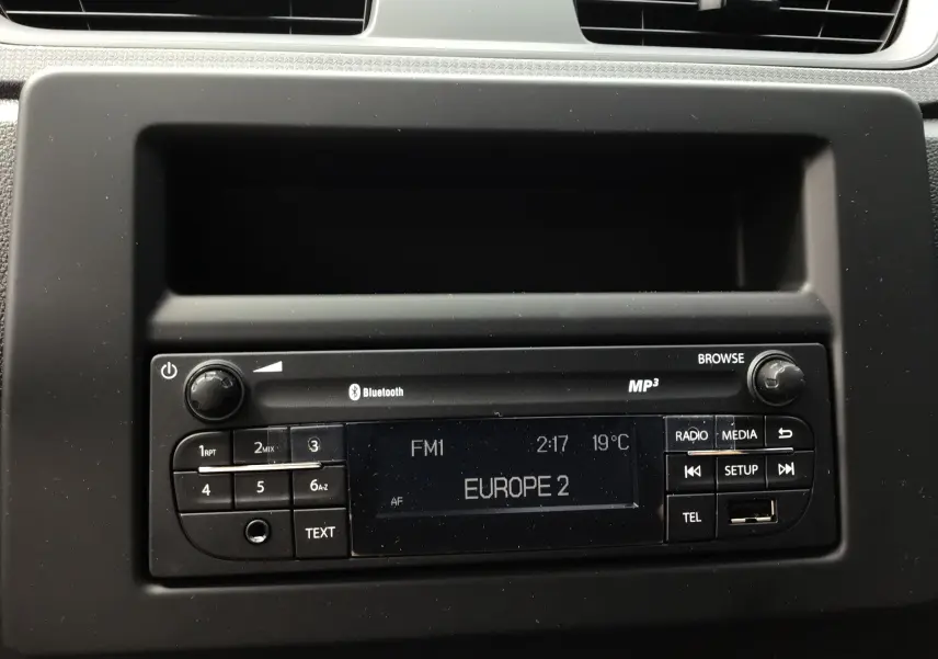 Gros plan sur la radio Bluetooth du tableau de bord noir du Renault Express Van blanc 2024, affichant Europe 2 FM.