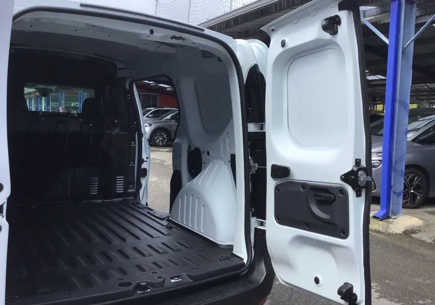Vue arrière ouverte du Renault Express Van blanc 2024 montrant l'espace de chargement protégé par un plancher PVC noir.