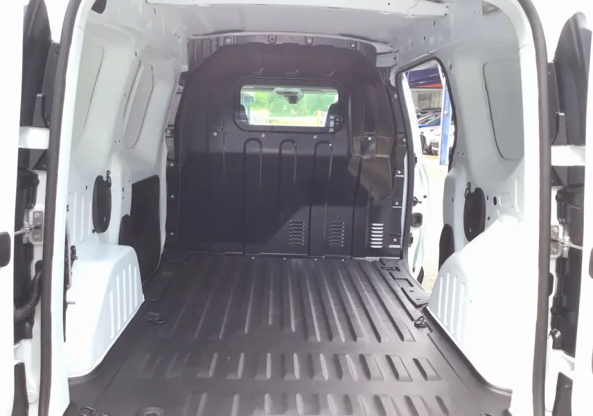 Vue intérieure arrière du Renault Express Van blanc 2024, montrant l'espace de chargement avec plancher PVC et cloison noire.