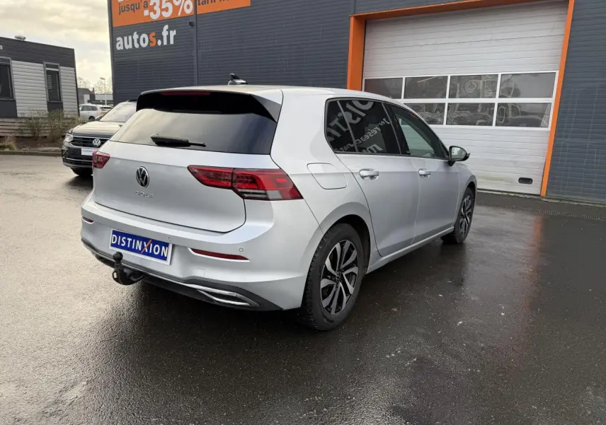 Volkswagen Golf 8 Life Active argent métallisé vue 3/4 arrière droit avec attelage escamotable et vitres surteintées.