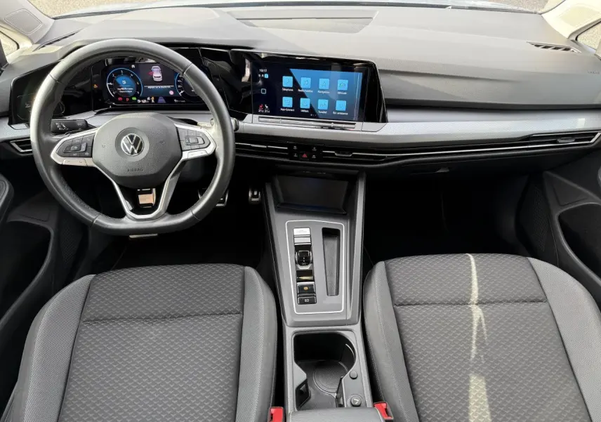 Vue intérieure avant de la Volkswagen Golf VIII Life Active avec tableau de bord digital et volant multifonction cuir.