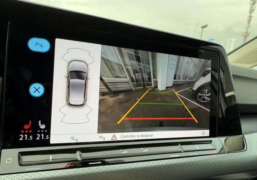 Écran de caméra de recul et capteurs de stationnement d'une Volkswagen Golf argent métallisé, vue intérieure avant.