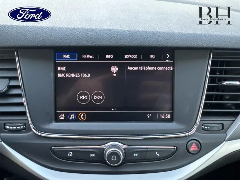 Écran tactile multimédia central de la console d'une Opel Astra gris minéral, avec affichage radio FM.