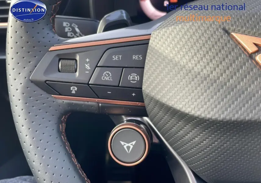Gros plan sur le volant cuir perforé de la CUPRA Formentor avec commandes multifonctions et logo Cupra cuivré.