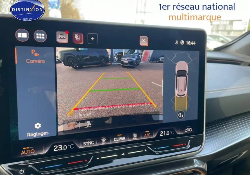 Écran tactile intérieur montrant la caméra de recul et l’aide au stationnement du CUPRA Formentor blanc Nevada.