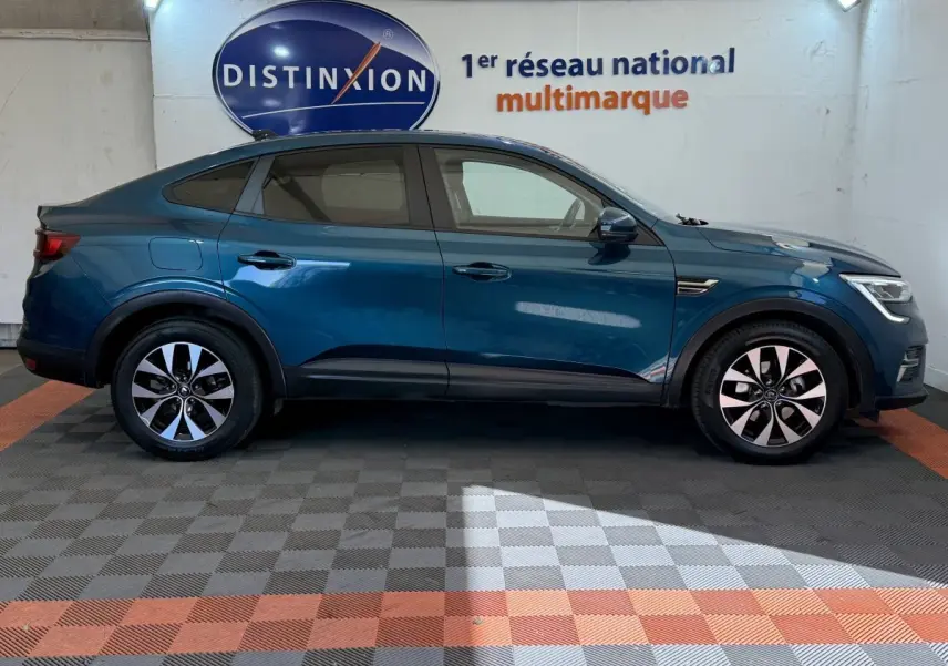 Profil latéral droit d'une Renault Arkana Business E-TECH 145 bleu, avec jantes alliage et lignes fluides.