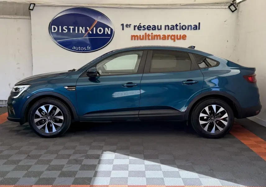 Profil côté gauche d'un Renault Arkana Business E-TECH 145 bleu, avec jantes alliage et ligne de toit plongeante.