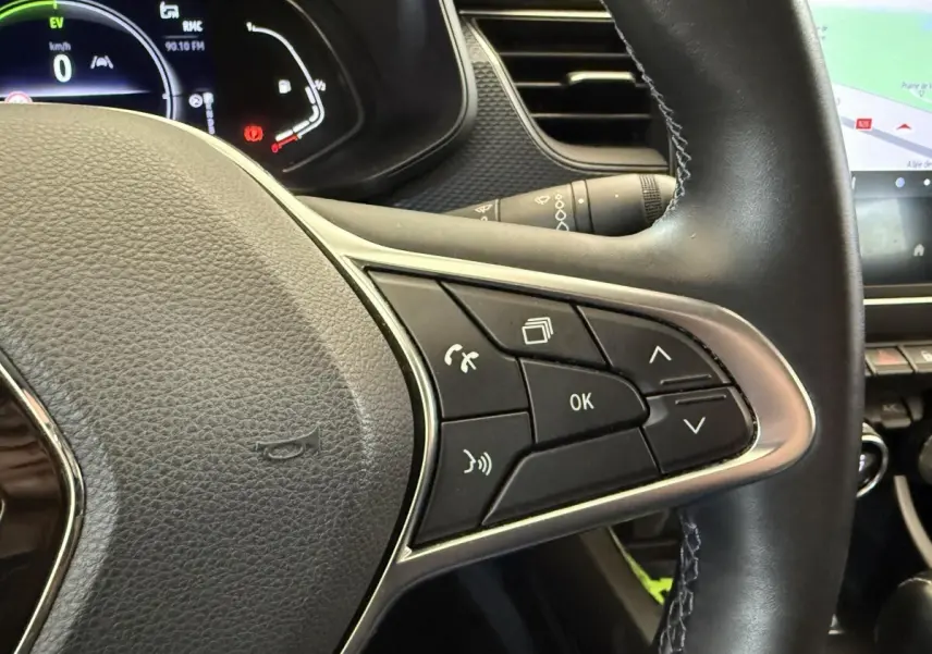 Gros plan sur le volant cuir et alu du Renault Arkana Business E-TECH 145 avec commandes multifonctions visibles.