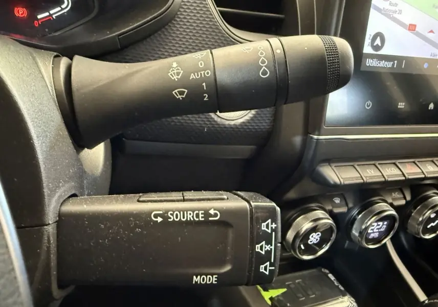 Gros plan sur la commande multimédia et les commandes d’essuie-glace du tableau de bord noir du Renault Arkana Business E-TECH 145.