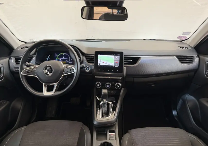 Vue intérieure frontale du tableau de bord du Renault Arkana Business E-TECH 145 avec écran tactile et volant multifonctions cuir.