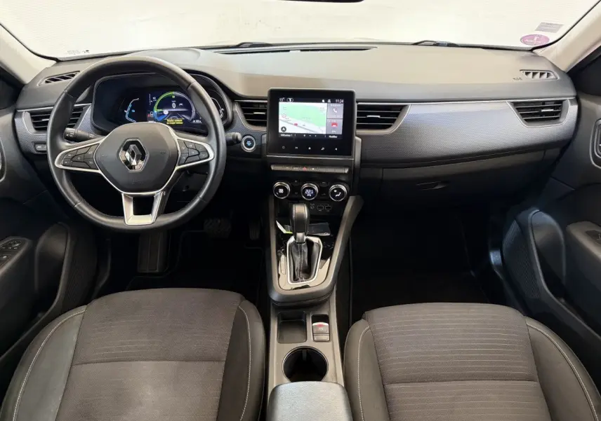 Vue intérieure avant du Renault Arkana Business E-TECH 145 2022, tableau de bord noir avec écran tactile central et volant multifonctions.