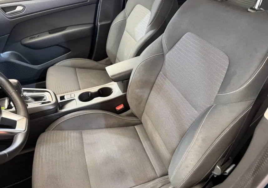 Vue intérieure côté conducteur du Renault Arkana Business E-TECH 145, sièges gris avec accoudoir central et console.