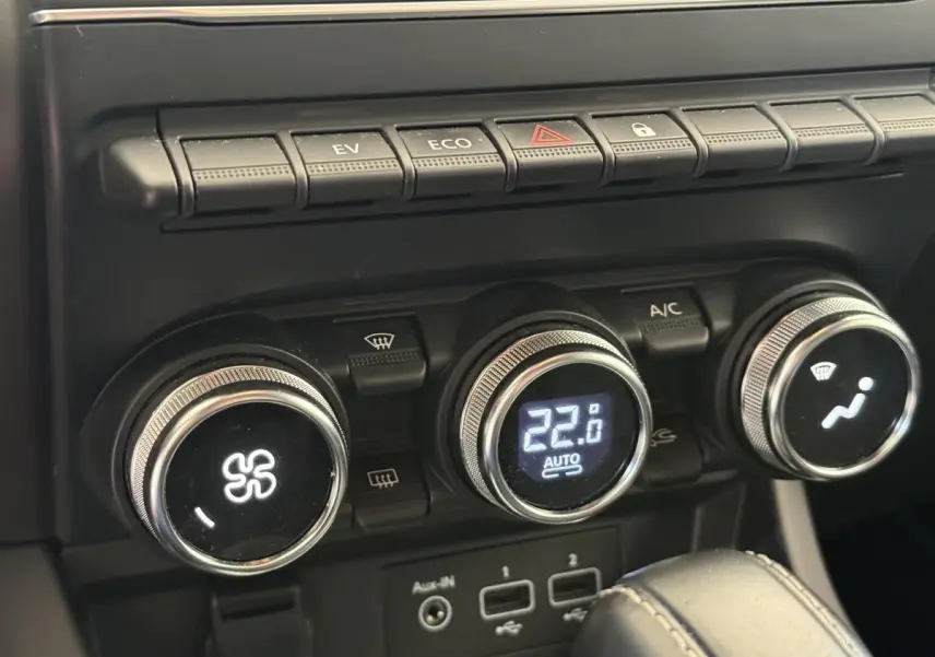 Gros plan sur les commandes de climatisation digitale et boutons de fonction du tableau de bord du Renault Arkana Business E-TECH 145.