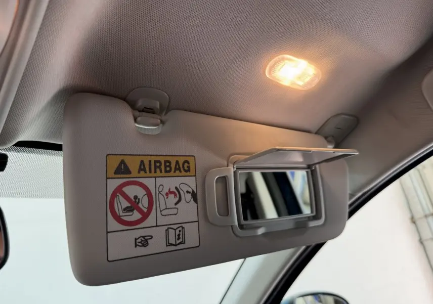 Pare-soleil côté conducteur avec miroir éclairé et avertissement airbag dans l’habitacle du Renault Arkana bleu 2022.