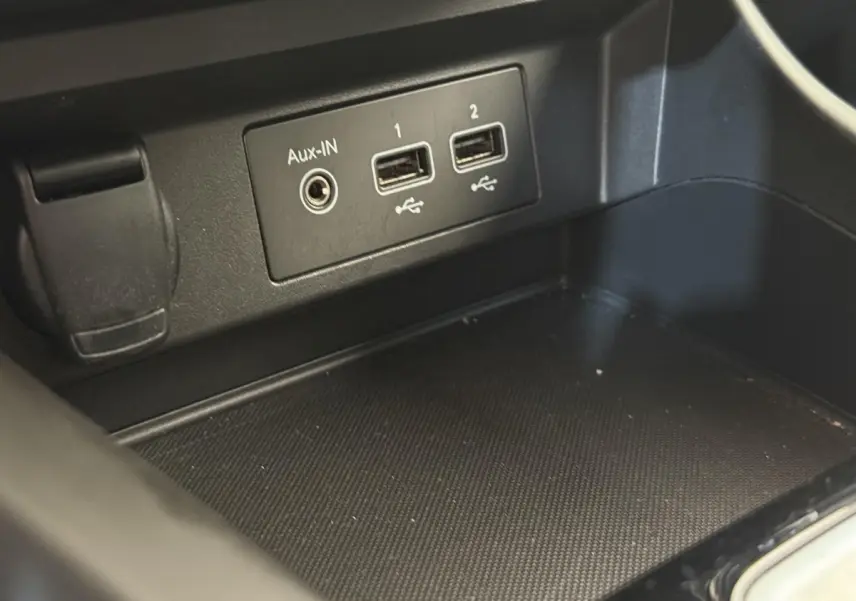 Gros plan sur les ports USB et Aux-IN dans la console centrale noire du Renault Arkana Business E-TECH 145.