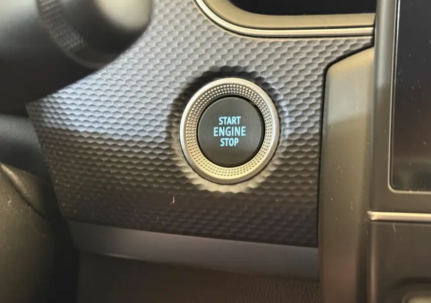 Gros plan sur le bouton start engine stop entouré d’un décor texturé noir dans l’habitacle du Renault Arkana Business E-TECH 145.