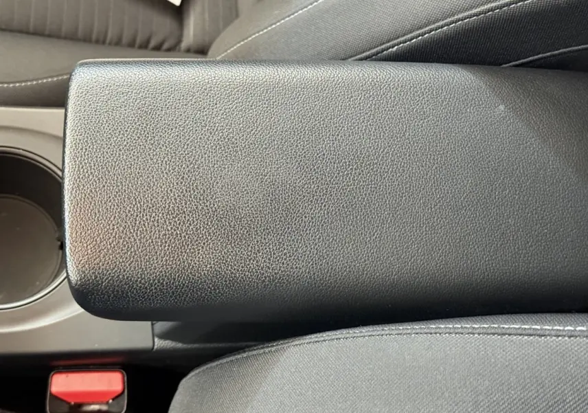 Gros plan sur l'accoudoir central noir en cuir synthétique de l'habitacle du Renault Arkana Business E-TECH 145.