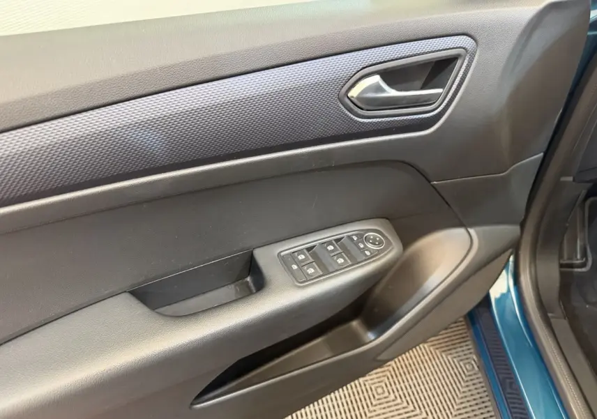 Vue rapprochée de la porte avant gauche bleu métallisé du Renault Arkana avec commandes électriques des vitres et poignée intérieure.