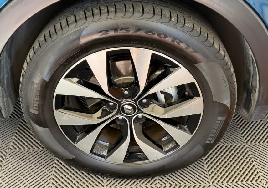 Gros plan sur la jante alu bicolore et le pneu Pirelli d'une Renault Arkana Business E-TECH bleu 2022.