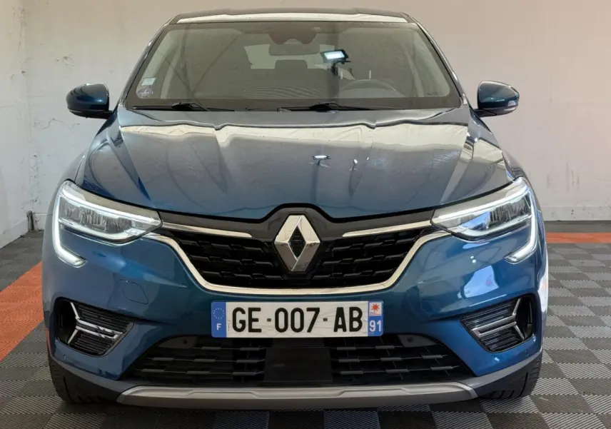Vue frontale d'une Renault Arkana Business E-TECH 145 bleu avec calandre noire et feux LED distinctifs.
