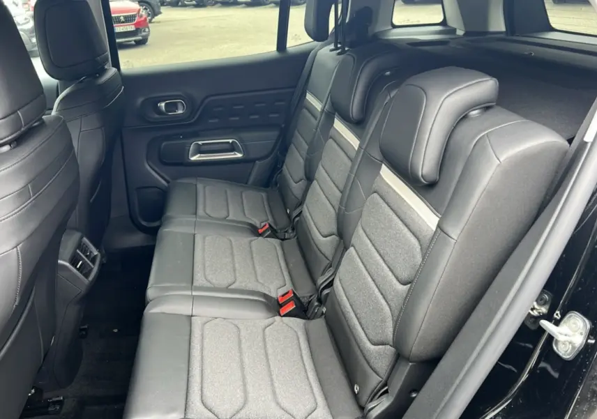 Vue intérieure côté droit des trois sièges arrière individuels gris foncé du Citroën C5 Aircross Hybrid 2025 noir.