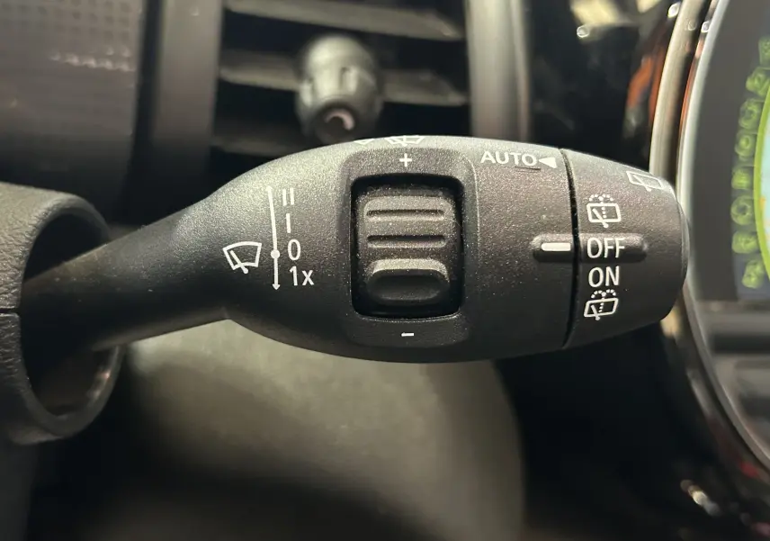 Gros plan sur la manette de commande des essuie-glaces dans l’habitacle d’une MINI 5P bleu, côté gauche du volant.