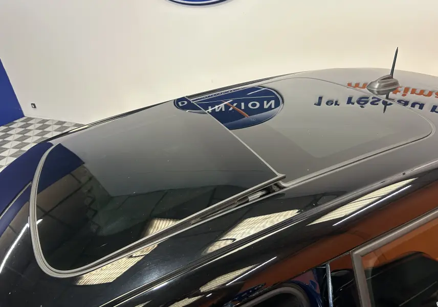 Vue en plongée du toit ouvrant vitré du MINI 5 portes Cooper D bleu foncé, soulignant sa finition brillante.