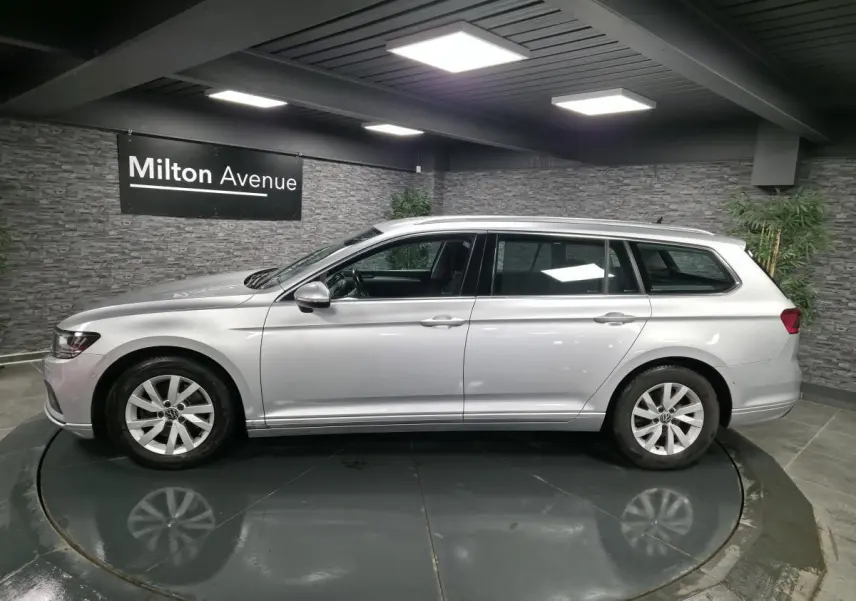 Vue de profil côté gauche d'une Volkswagen Passat SW gris métallisé, en intérieur sur plateau tournant.