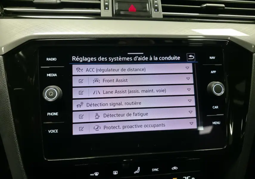 Écran tactile central de la Volkswagen Passat SW 2021 affichant les réglages des aides à la conduite.