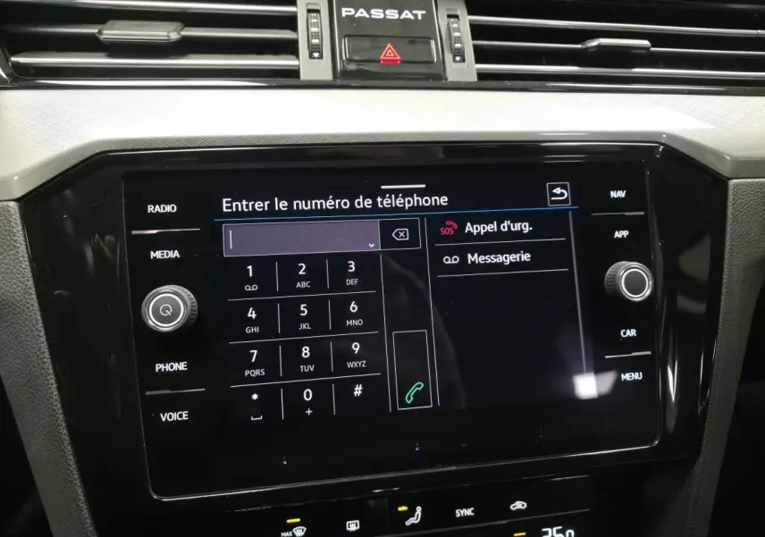 Écran tactile central de la Volkswagen Passat SW 2021 affichant le clavier pour entrer un numéro de téléphone.