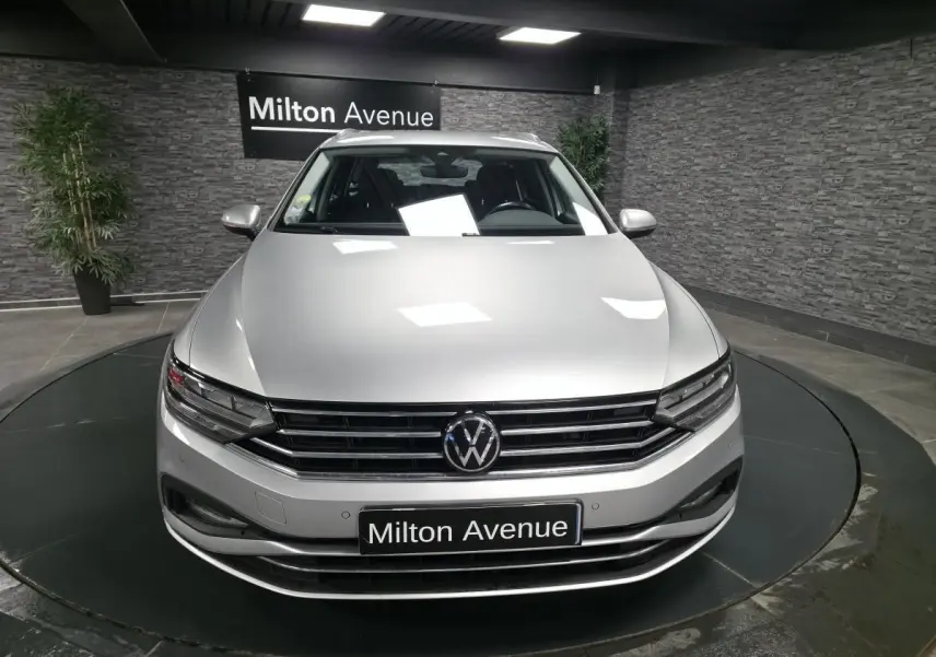 Vue avant d'une Volkswagen Passat SW gris métallisé 2021 avec calandre chromée et logo VW bien visible.