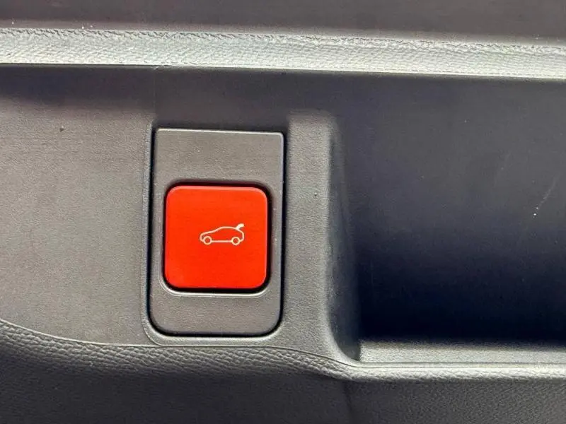 Bouton rouge d'ouverture électrique du coffre sur panneau intérieur noir d'un DS4 Gris Platinium 2023.