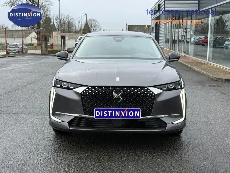Vue frontale d'une DS4 2023 gris Platinium avec calandre noire à motifs losanges et feux LED verticaux distinctifs.