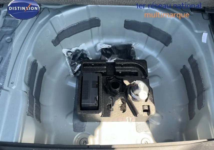 Gros plan sur le compartiment de roue de secours gris métallique d'une SEAT Arona 2026, avec outils de bord rangés.
