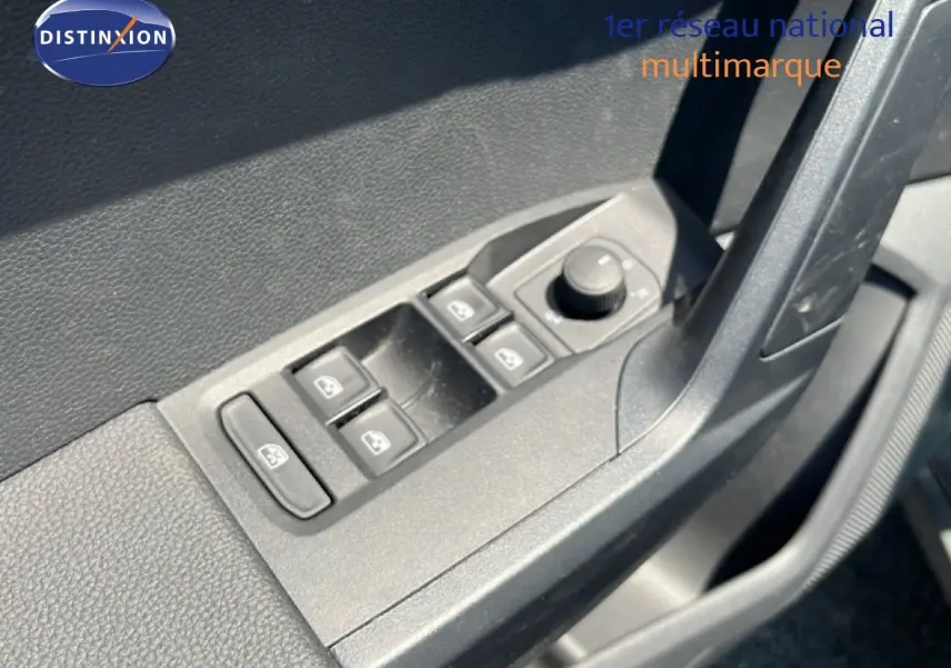 Gros plan sur les commandes des vitres et rétroviseurs côté conducteur du SEAT Arona gris Magnetic Metal avec toit blanc.