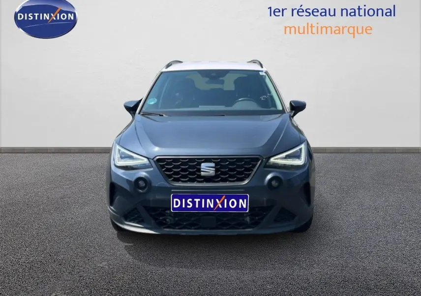 Vue avant d'une SEAT Arona gris magnetic metal avec toit blanc, mettant en valeur ses phares LED anguleux.