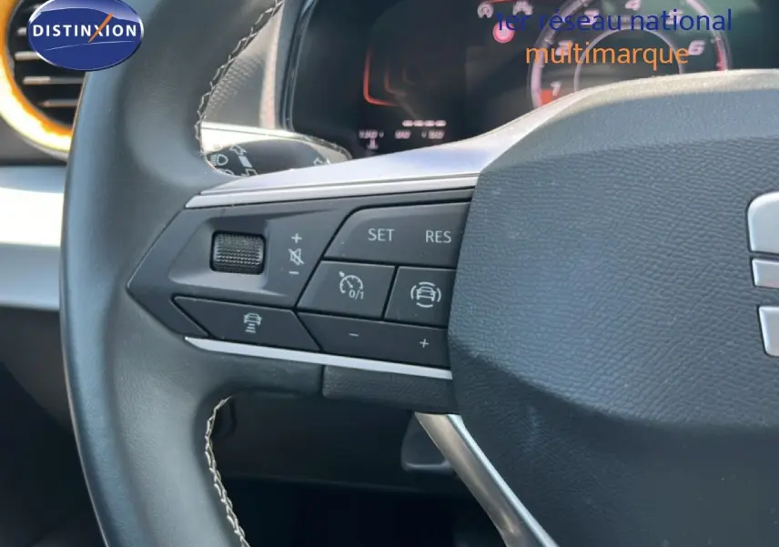 Gros plan sur le volant de la SEAT Arona 2026, montrant les commandes multifonctions à gauche avec tableau de bord digital en arrière-plan.