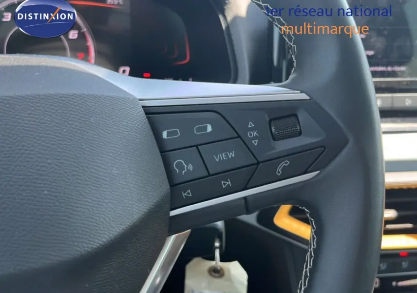 Gros plan sur le volant noir avec commandes multifonctions du SEAT Arona gris Magnetic 2026, intérieur moderne et écran digital.