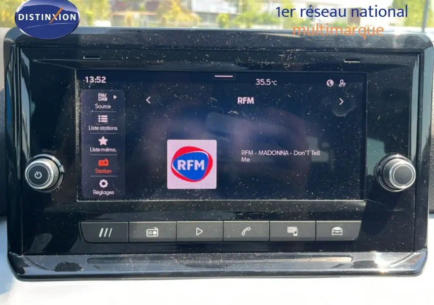 Vue rapprochée de l’écran tactile central du SEAT Arona 2026 affichant la radio RFM, entouré de commandes noires.