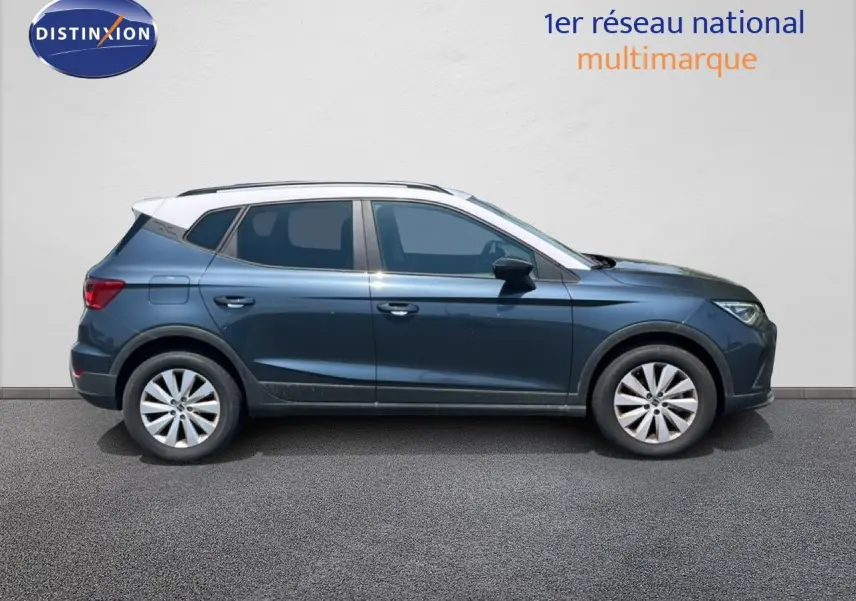 Vue de profil côté gauche d'un SEAT Arona gris Magnetic avec toit blanc, roues alliage et lignes dynamiques.