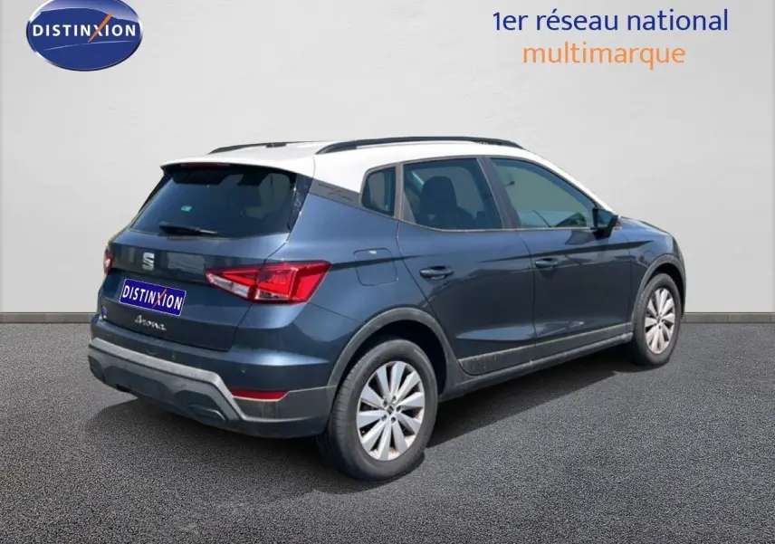 Vue 3/4 arrière droite d'une SEAT Arona gris magnetic avec toit blanc, mettant en valeur son design compact et ses feux arrière LED.