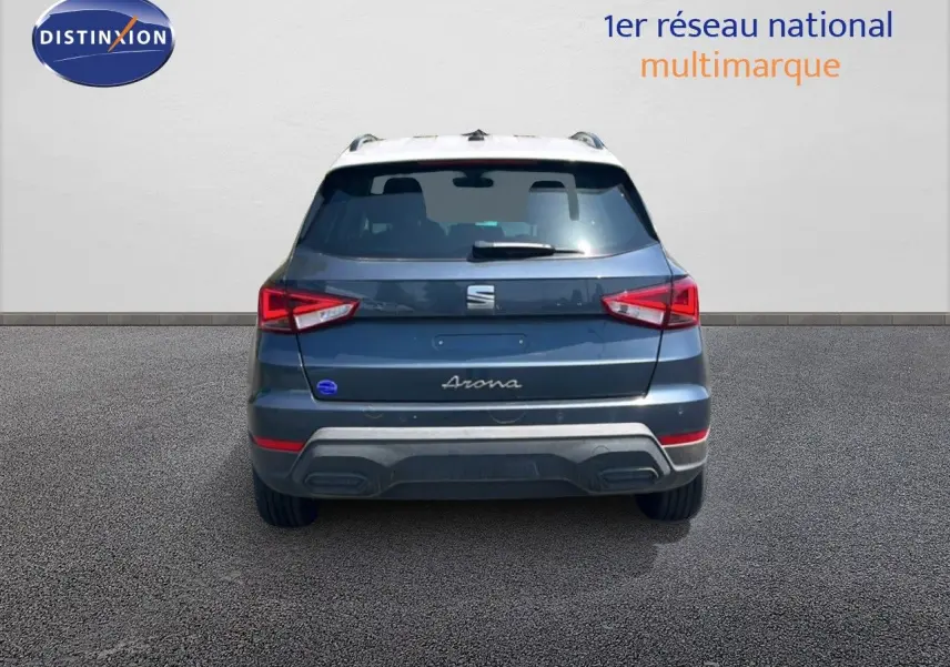 Vue arrière d'un SEAT Arona gris Magnetic avec toit blanc, mettant en valeur les feux arrière et le logo central.