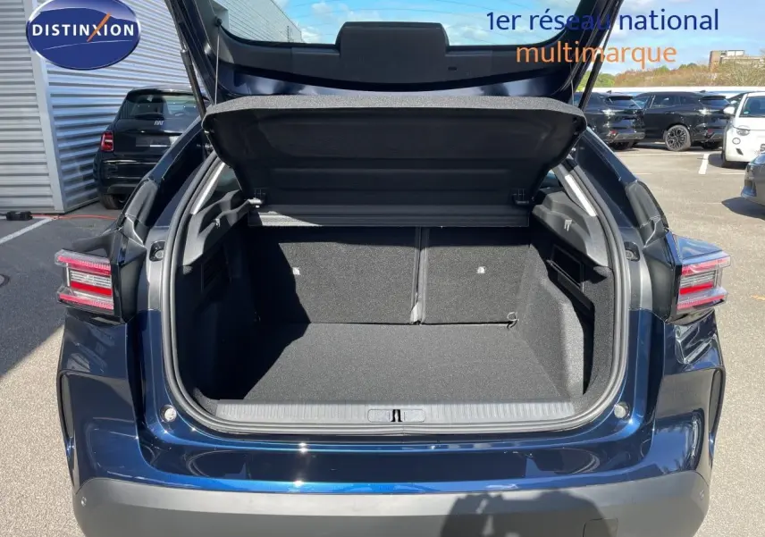 Coffre ouvert vu de l'arrière d'une Citroën C4 Hybrid 145ch bleu eclipse métal, avec feux arrière LED distinctifs.