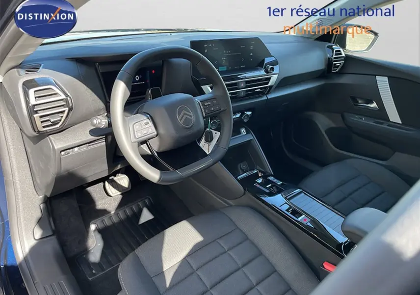Intérieur de la Citroën C4 Hybrid 145ch, vue côté conducteur montrant le tableau de bord et les sièges noirs.