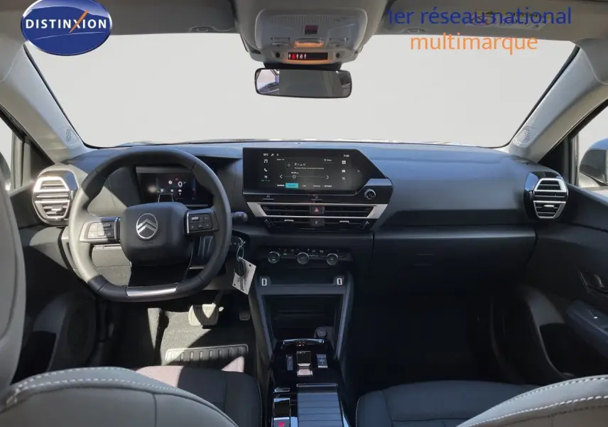 Vue intérieure avant du tableau de bord et volant noir d'une Citroën C4 Hybrid 145ch BVA Plus, finition moderne et épurée.