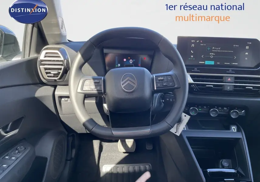 Vue intérieure centrée sur le volant et tableau de bord numérique de la Citroën C4 Hybrid 145ch, ambiance noire moderne.